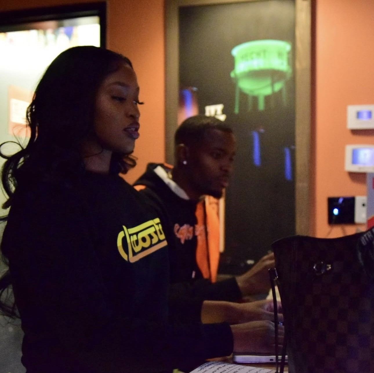 Aja at her laptop calling The Hail Zel Show, with Hail Zel beside her