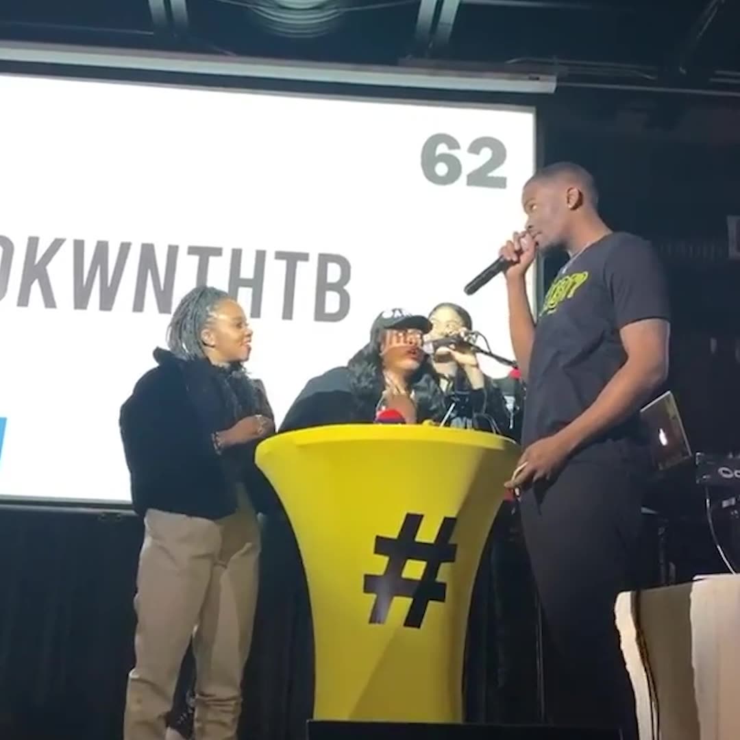 Players at yellow hashtag podiums onstage, an acronym and a countdown on the big screen behind them