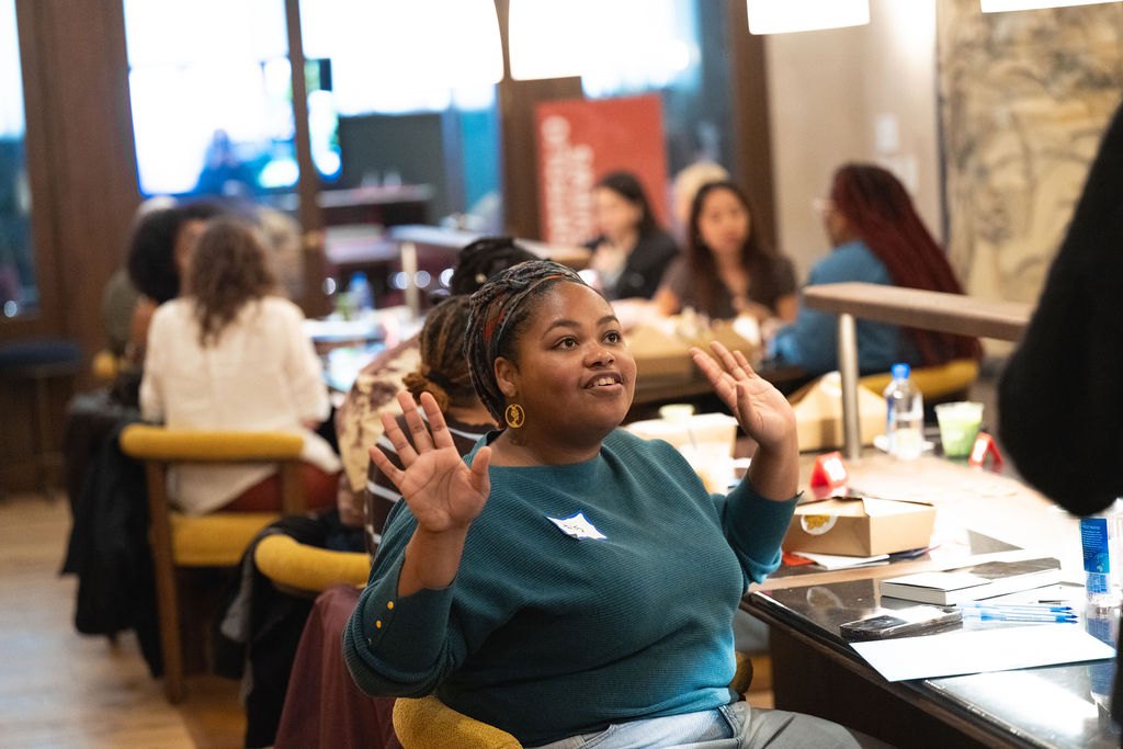 A participant mid-conversation at a POV portfolio review table