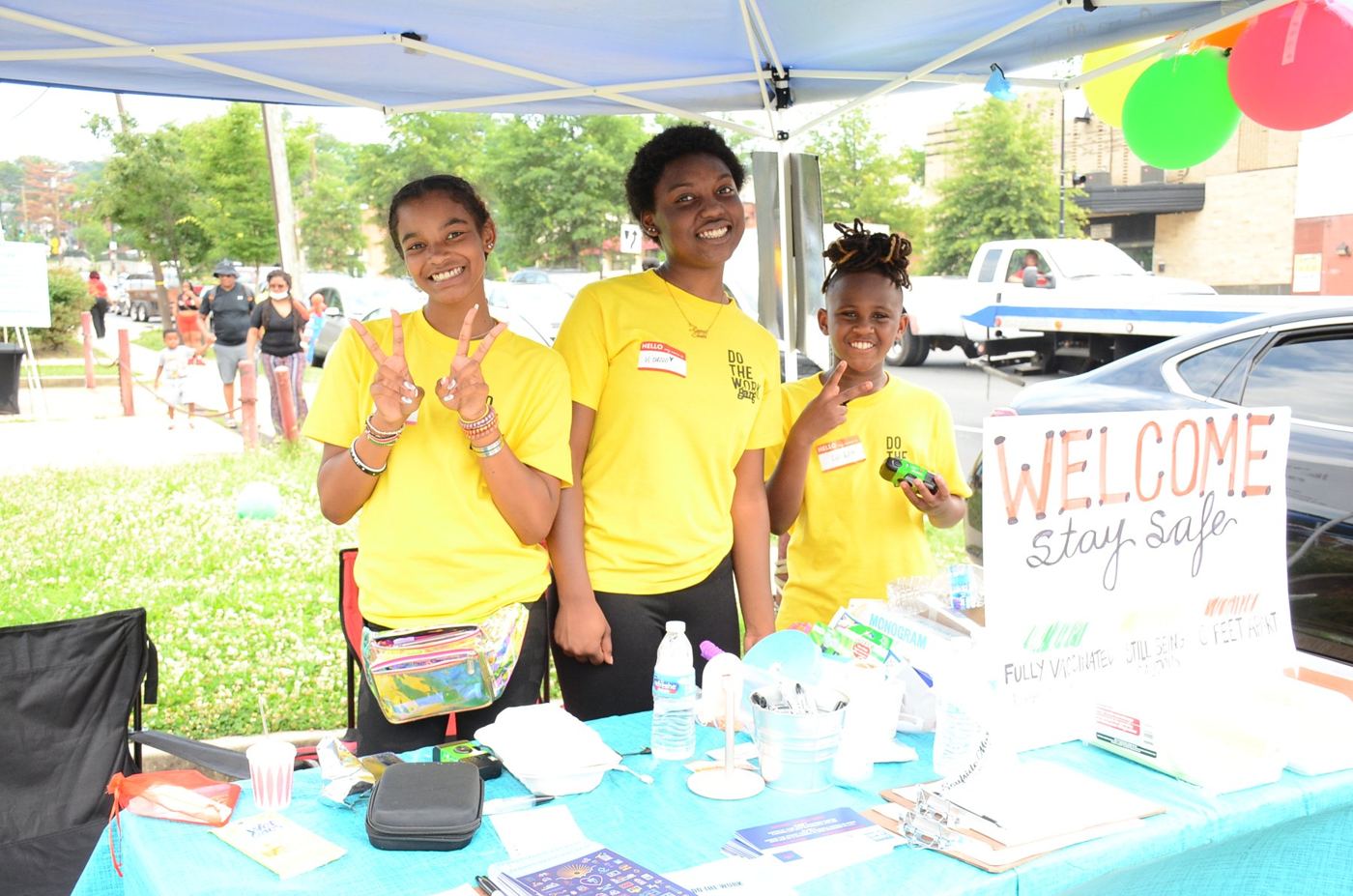 Three DOTHEWORK crew members at the welcome table at Soufside Market
