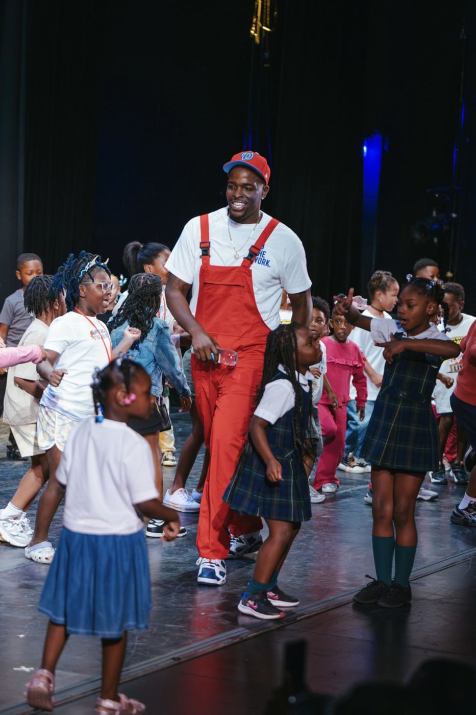Mr. Prather dancing onstage surrounded by children