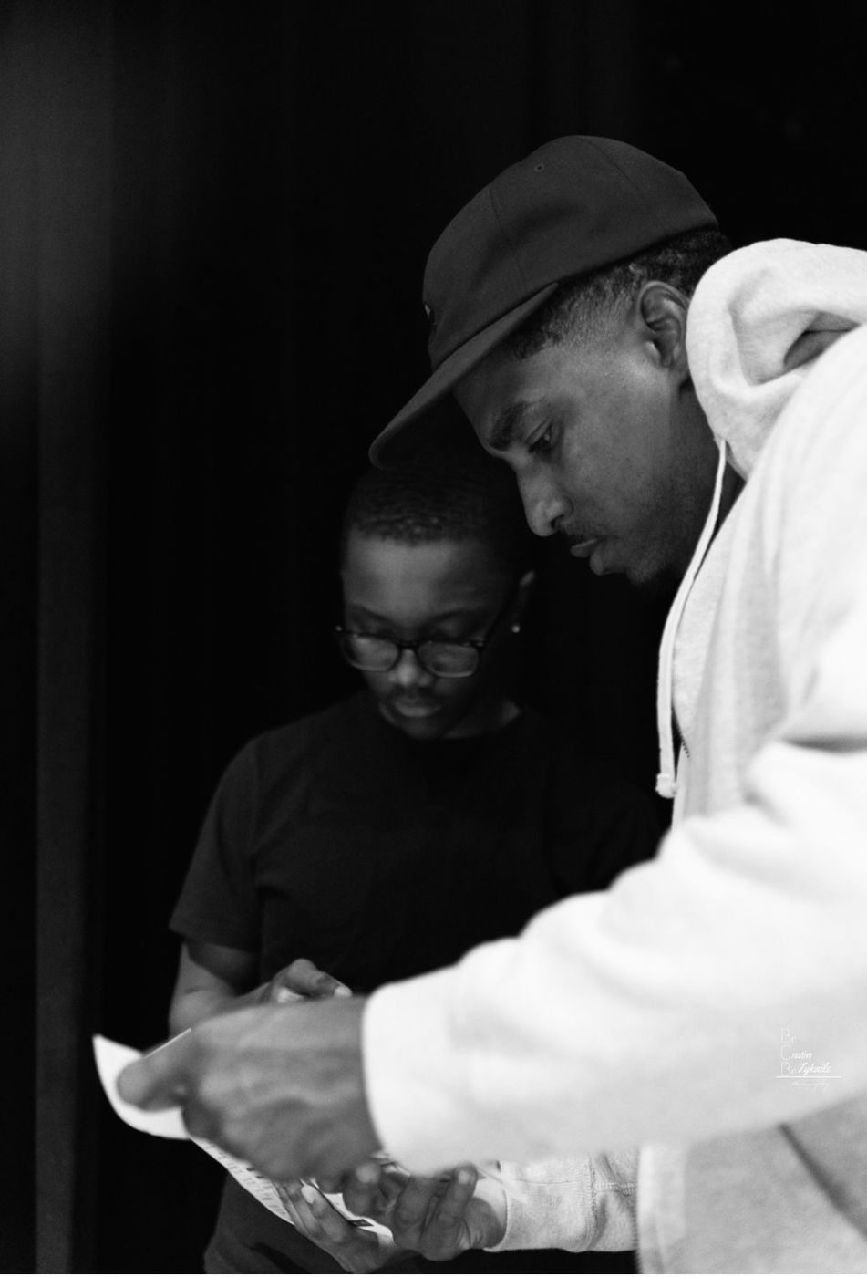A crew member and an adult going over notes on paper
