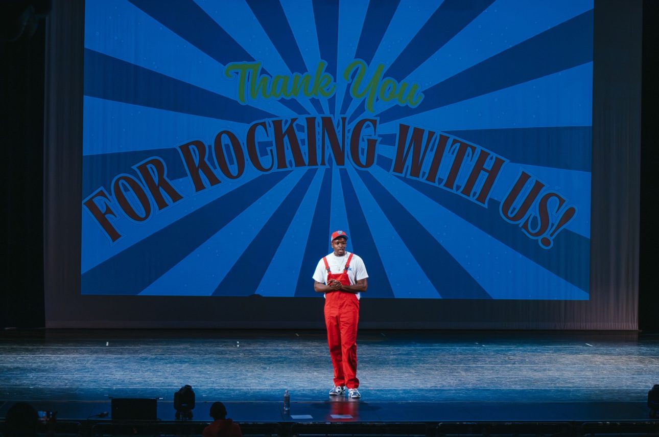 Mr. Prather alone on stage under a giant screen that reads Thank You For Rocking With Us!